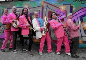 Die Musiker von Fransen mit ihren instrumentn vor einer Graffity-Wand